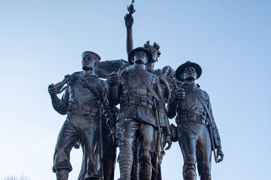 Bronze statue of soldiers against blue sky, symbolizing patriotism in Washington, USA.